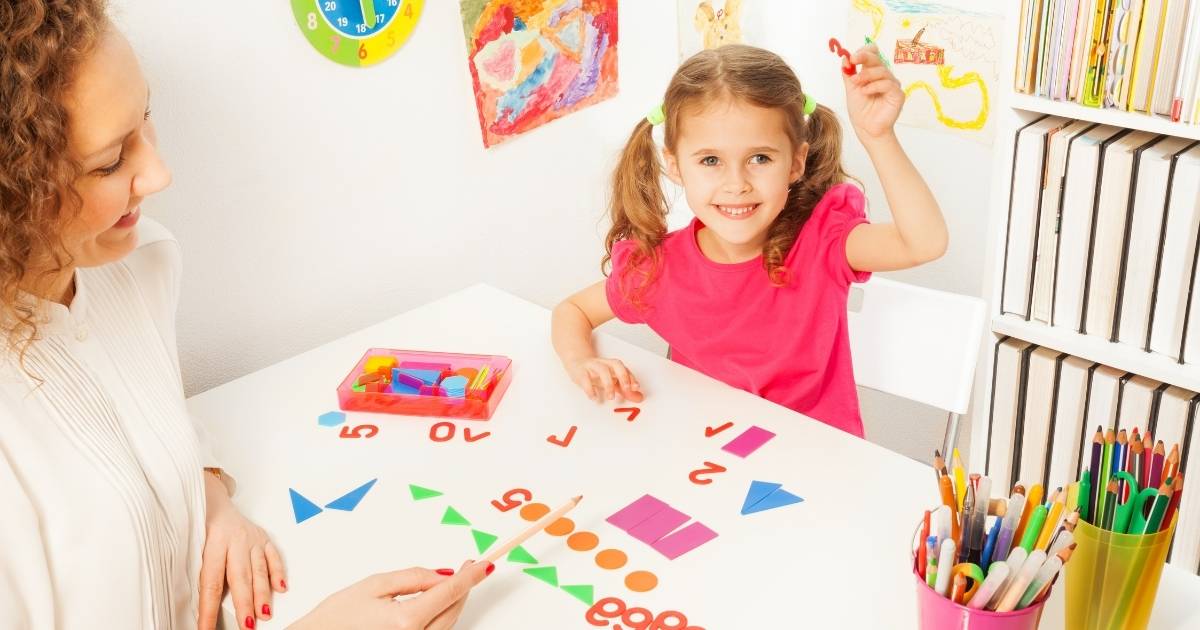 Young girl in pink shirt using fun learning games in the classroom