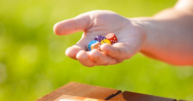Child holding multi-colored dice while playing a math game